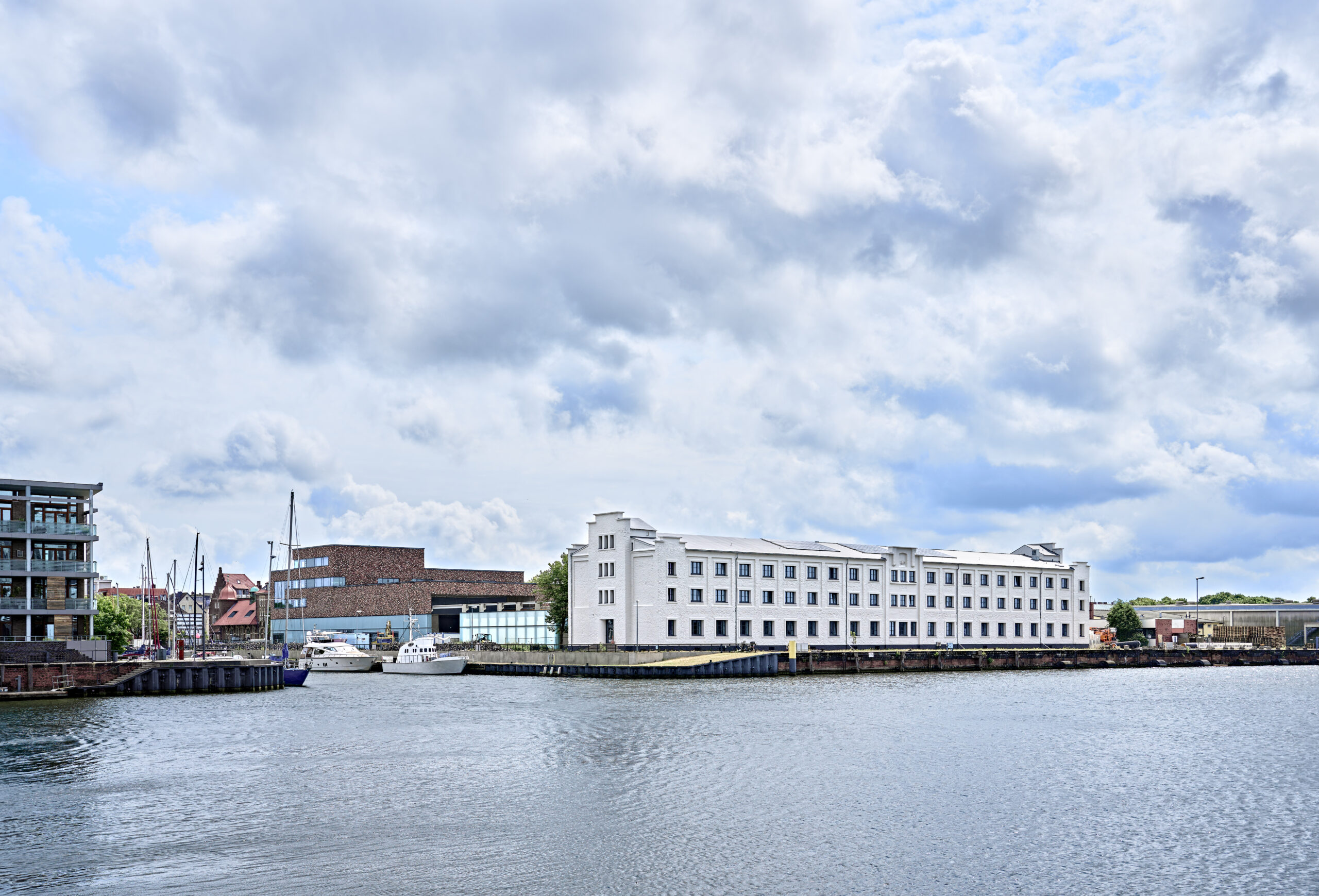 Hafenbecken im Fischereihafen mit einem Bürogebäude. Der Fischereihafen ist Standort für viele verschiedene Unternehmen.