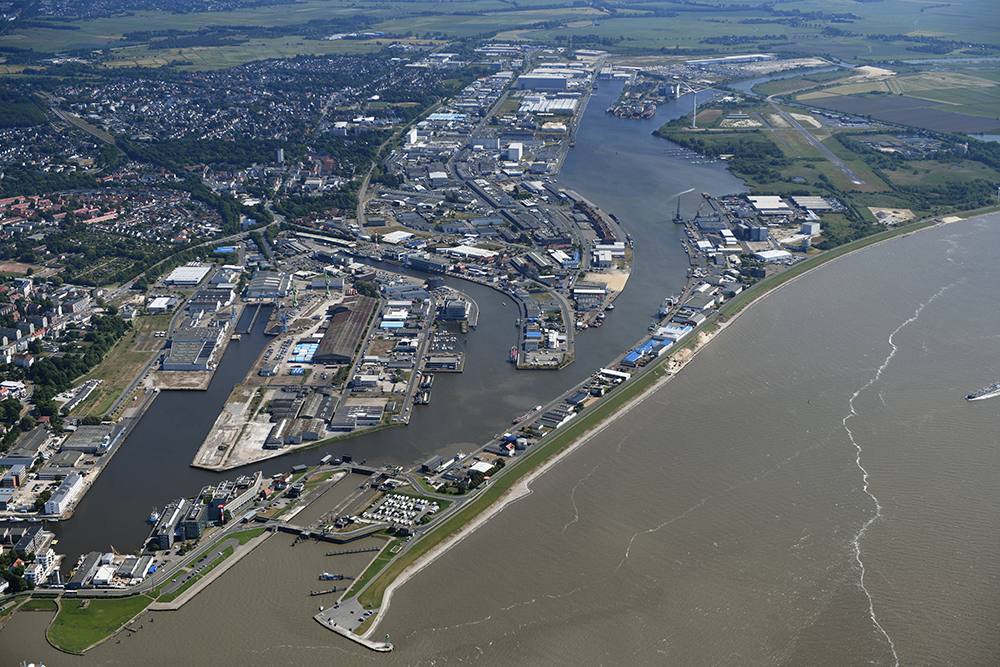 Der Fischereihafen aus der Luft von Norden aus mit Stadtgebiet Bremerhaven, Industrie, Hafenbecken und der Weser.