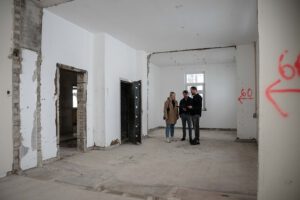 Dre Personen in einem Gebäude, das gerade saniert wird.