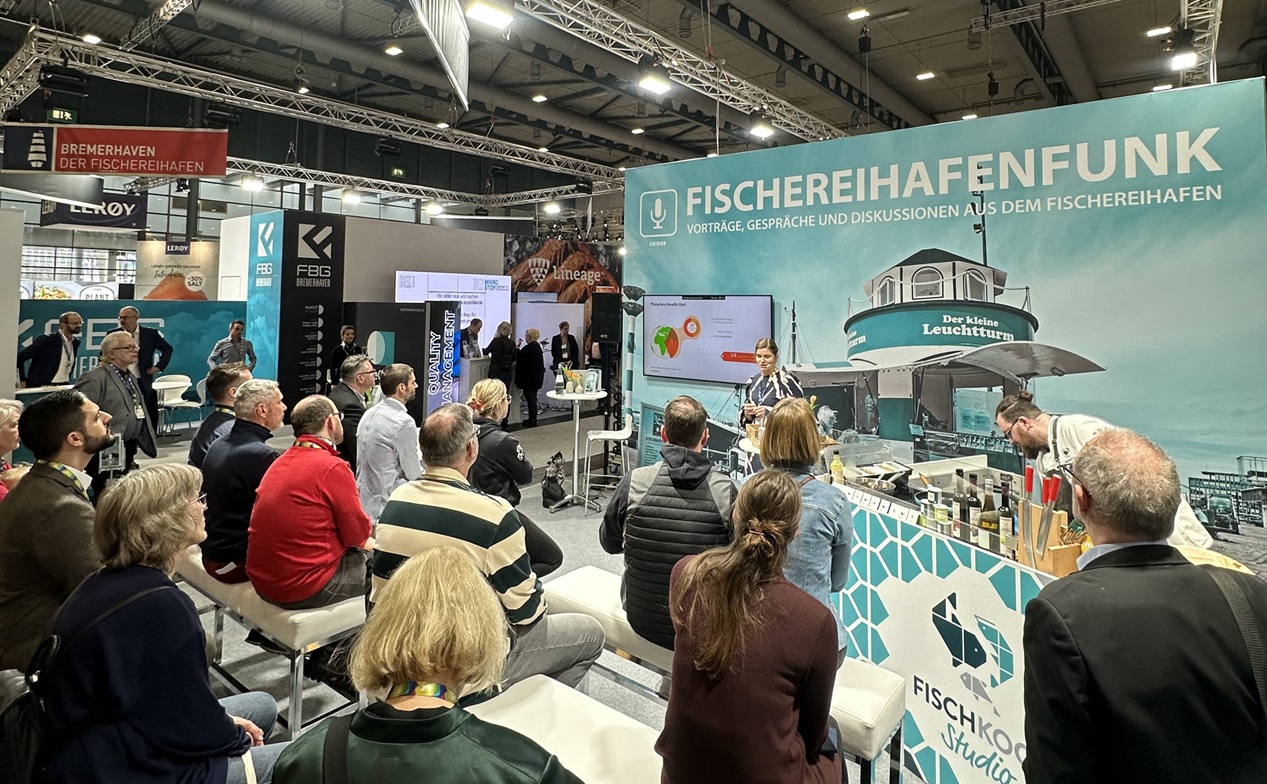 Eine Frau hält am Messestand Fischereihafenfunk einen Vortrag.