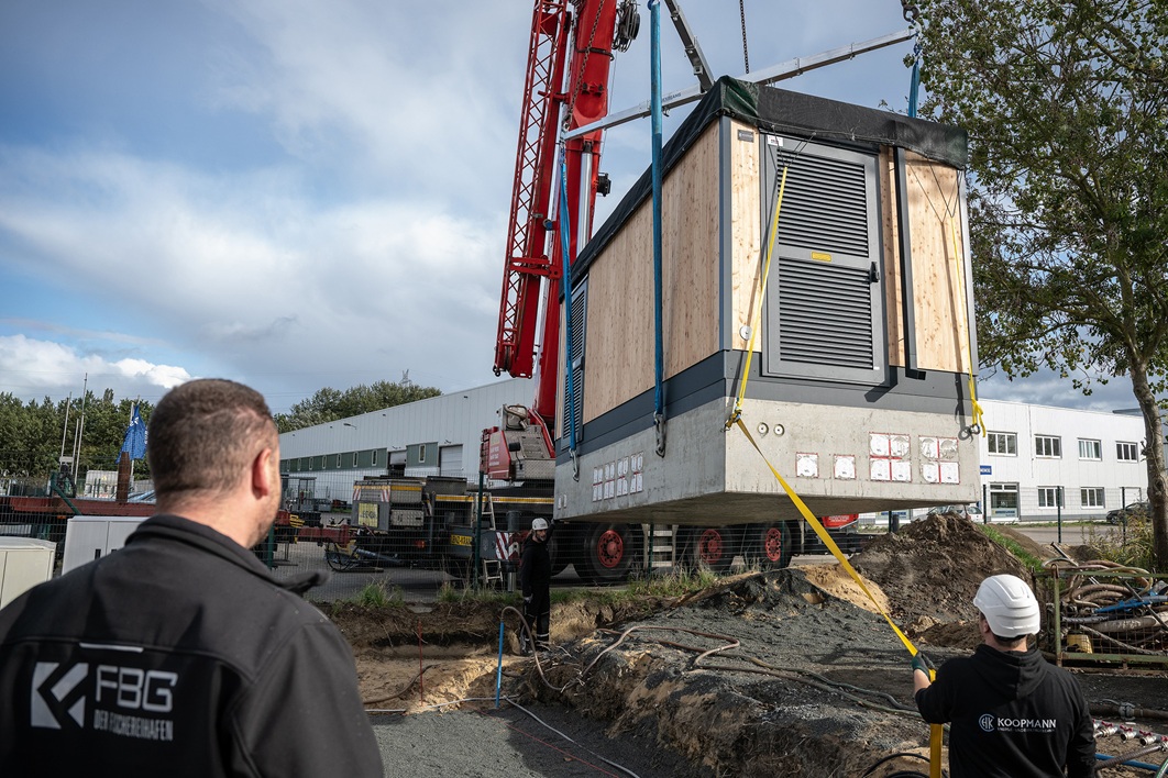 FBG-Verteilstation-Heumer – Web Netzstation aus natürlichen Materialien im Fischereihafen errichtet. Sie wurde mit einem Kran platziert.